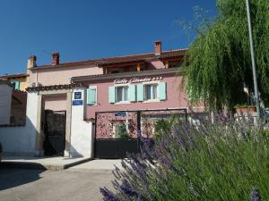 a pink and white building with a garage at Villa Claudia in Fažana