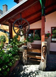 a porch with a wooden bench and aoked wheel at Penzion Plesnivec in Poprad