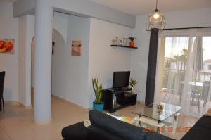 een woonkamer met een bank en een tv bij Luxury Apartment in Paphos City