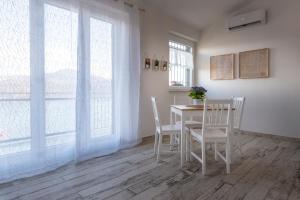 a dining room with a table and chairs and windows at Il bianconido in Castel Gandolfo +13 photos