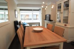 a dining room with a wooden table and chairs at Appartement Sincfala in Knokke-Heist