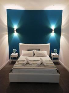 a bedroom with a large bed with blue walls at LOFT 99 in Palermo