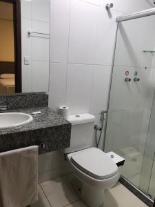 a bathroom with a toilet and a sink and a shower at Hotel Moura in Brumado