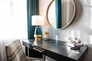 a dressing table with a mirror and a chair at Magnolia Hotel Omaha in Omaha +79 photos