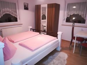um quarto com 2 camas, uma mesa e uma janela em Isas Apartment em Füssen
