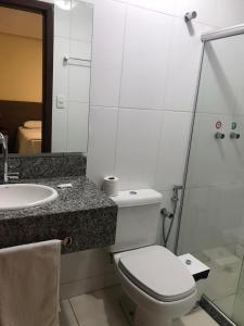 a bathroom with a toilet and a sink and a mirror at Hotel Moura in Brumado