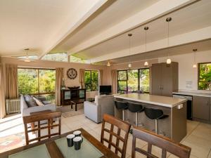 a kitchen and living room with a table and chairs at At Cathedral Cove - Hahei Holiday Home in Hahei