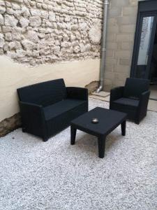 two black chairs and a coffee table in front of a wall at Le studio de Molière DELUXE in Montluçon