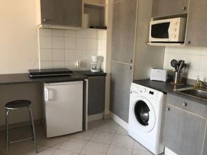 a kitchen with a washing machine and a microwave at Studio CENTRE CROISETTE in Cannes