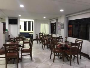 a restaurant with tables and chairs in a room at Hotel Moura in Brumado