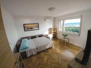 1 dormitorio con cama y ventana grande en Garden View Apartments, en Ankaran