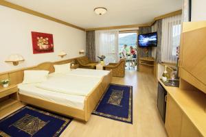 ein Hotelzimmer mit einem Bett und einem TV in der Unterkunft Seehotel Princes in Sankt Kanzian am Klopeiner See