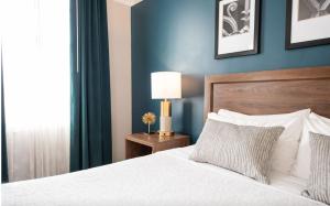 a bedroom with a bed and a blue wall at Magnolia Hotel Omaha in Omaha