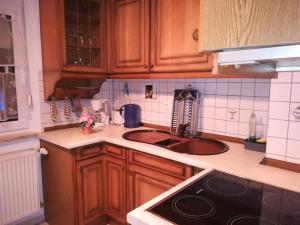 a kitchen with wooden cabinets and a sink at Isas Apartment in Füssen