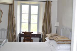 a bedroom with a bed and a desk and a window at Maison vigneronne in Montlaur
