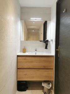 ein Bad mit einem Waschbecken und einem Spiegel in der Unterkunft Colmar Suites - Résidence in Colmar