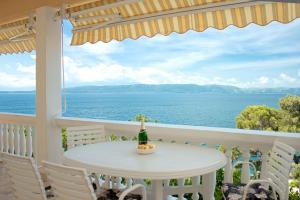 a table on a balcony with a view of the ocean at Apartments and rooms Gojko - 50 m from the beach in Živogošće