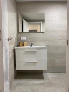 a bathroom with a white sink and a mirror at WISH SUITE NIEBLA DE SEVILLA in Seville