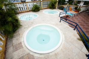 two swimming pools in a patio with two chairs at Hotel Baluarte Cartagena Boutique in Cartagena de Indias