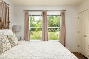 een slaapkamer met een bed en een groot raam bij Bear Creek Cottage in Manchaca