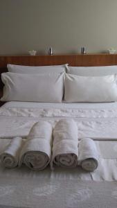 Una cama con tres rollos de toallas. en Plaza Independencia en Mendoza