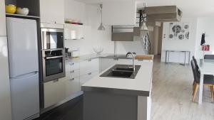 een witte keuken met een wastafel en een koelkast bij Ty Koukset in Baud