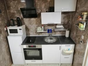 a small kitchen with a sink and a microwave at Apartment by the park in Imatra +18 photos
