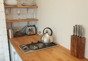 a kitchen counter with a stove with a tea kettle at SeaView Retreat -Amazing Ocean Views and Outdoor bath in Waiuku