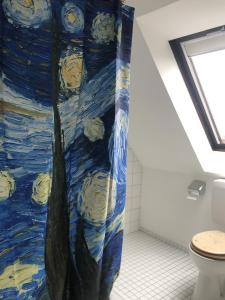a bathroom with a shower curtain in a room with a toilet at Einzel-Apartment Düsseldorf Oberkassel in Düsseldorf