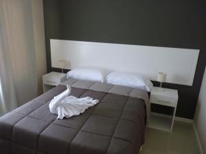 a bedroom with a bed with a white dress on it at Hotel Bender in Coronel Suárez