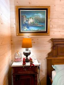 a lamp on a table in a bedroom with a painting at Brvnare Mrkic in Kremna