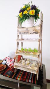 a ladder shelf with a health zone sign and flowers at Embassy Quito in Quito