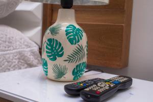 two remote controls sitting on a table next to a vase at Ocean Blue Beach in San Andrés