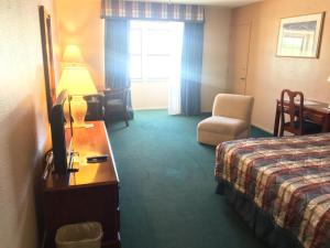 a hotel room with two beds and a television at Hardman House in Carson City