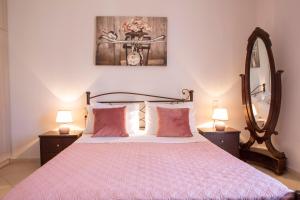 a bedroom with a bed and a mirror and lamps at Thea Family Apartment 2 in Yenion