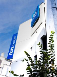 a white building with a blue sign on it at ibis budget Angoulême Centre in Angoulême