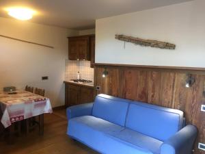 a living room with a blue couch and a table at Appartamenti & Wellness Piero Gros in Sauze dʼOulx +94 photos