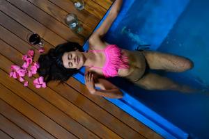 una mujer con un vestido rosa puesta junto a una piscina en Turrim Dei Hotel Boutique, en Barbosa