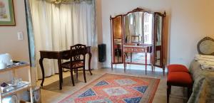 sala de estar con mesa y espejo en Malva Suite en Salta