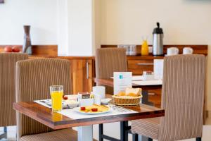 a table with a plate of food and a glass of orange juice at El Dorado Express Hotel in Iquitos