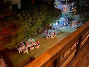 un grupo de personas sentadas en mesas en un jardín por la noche en Ayres Village Apart en Pinamar