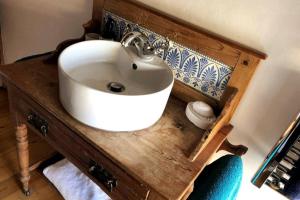 a bathroom with a white sink on a wooden counter at Dunsley Cottage in Staithes +47 photos