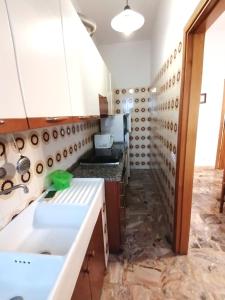 クプラ・マリッティマにあるAppartamento CUPRAの洗面台付きのキッチン、パイプの壁