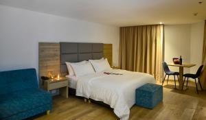 Habitación de hotel con cama y silla azul en Turrim Dei Hotel Boutique, en Barbosa
