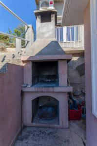 an outdoor pizza oven sitting on the side of a house at Apartments Ivan in Prizba