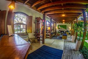 a living room with a wooden ceiling and a table at Pousada Ipê in São Sebastião