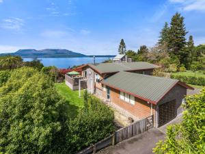 an aerial view of a house with a lake in the background at Lakeside Escape - Lake Tarawera Holiday Home in Lake Tarawera