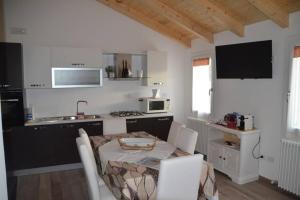 eine Küche mit einem Tisch und Stühlen sowie eine Küche mit einem Waschbecken in der Unterkunft La Casetta in Santa Margherita
