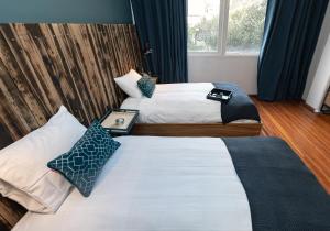 a hotel room with two beds and a window at Don Jacinto Stay&Sip in Mexico City