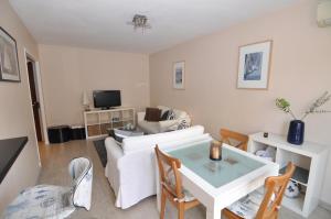 een woonkamer met een witte bank en een tafel bij Cosy One-Bedroom Apartment -StayInAntibes- Le Cosy in Antibes